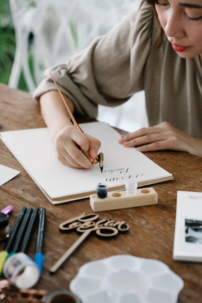 Close-up of a woman practicing calligraphy with ink on paper. Arts and crafts scene.